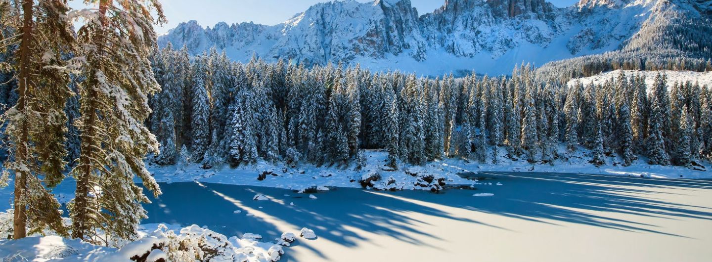 Sneeuw en zon bij Lago di Carezza in de Dolomieten